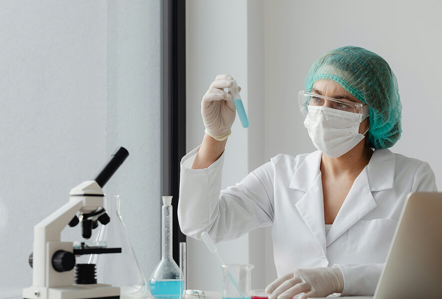 scientist in laboratory handling beakers